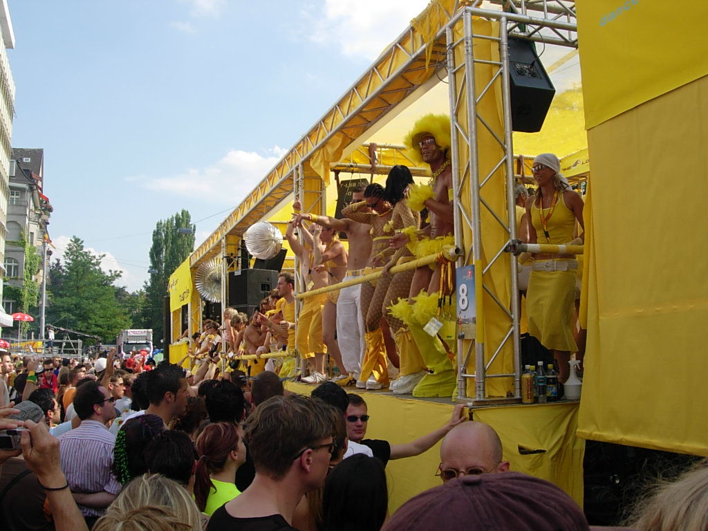 Abbildung 1 zeigt einen Musikwagen mit tanzenden Menschen auf der Street Parade 2004 in Zürich. Bild: SaMsX, gemeinfrei.