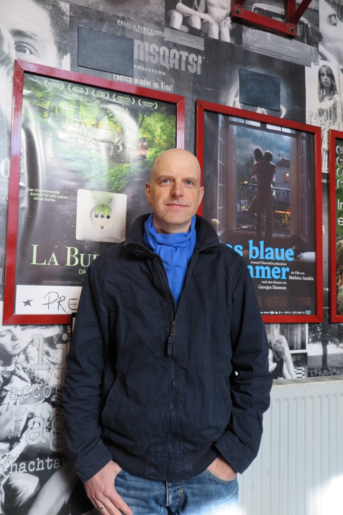 Jens Schanze vorm Filmplakat zu La Buena Vida